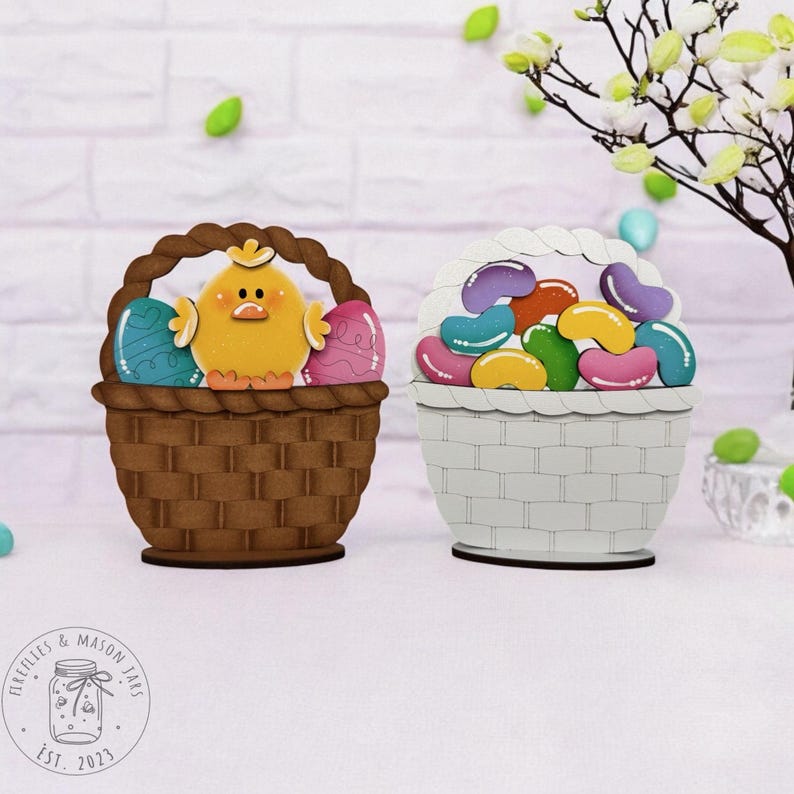 May include: Two wooden Easter baskets, one brown with a yellow chick and colourful eggs, the other white with colourful jelly beans. The baskets are on a white surface.