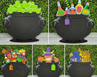 Puede incluir: Cuatro letreros negros en forma de caldero con diferentes temas de Halloween. El primer caldero está lleno de bolas verdes y blancas y tiene el texto "Witches Mason Jars". El segundo caldero tiene el texto "Our Place For Potion". El tercer caldero tiene una vaca de las tierras altas de dibujos animados y el texto "Boo Crew". El cuarto caldero tiene una casa de dibujos animados y el texto "Home Sweet Haunted Home".
