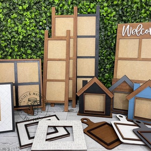 May include: A collection of wooden picture frames in various sizes and styles. The frames are made of natural wood with a rustic finish. Some frames have a black or gray paint finish. The frames are perfect for displaying photos, artwork, or other decorative items. The frames are arranged on a green background.
