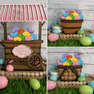 May include: A wooden market stall with a pink awning, filled with colourful jelly beans. The stall is on a wooden tray with a beaded border and surrounded by speckled Easter eggs.