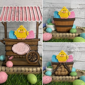 May include: A wooden Easter market stall with a pink and white striped awning, a yellow chick, and blue and pink eggs. The stall has a sign that says "Market Stand".