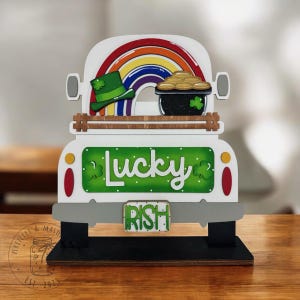 May include: White wooden truck with a rainbow, pot of gold, and shamrock on the back. The truck has a green and white "Lucky" sign and a green and white license plate that says "Irish".