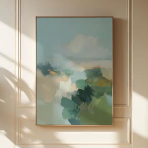 May include: Abstract landscape painting in a gold frame. The artwork features a blend of green, blue, and beige hues, creating a soft, atmospheric effect. The painting is mounted on a cream-coloured wall with decorative panelling, and is illuminated by natural light.