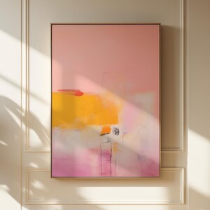 May include: Abstract painting with pink, yellow, and white colours. The painting is framed in a thin gold frame.