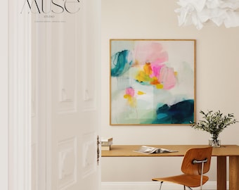 May include: An abstract painting with a wooden frame, featuring vibrant brushstrokes of pink, teal, yellow, and navy blue. The artwork hangs above a wooden desk with a chair. The text "MUSE STUDIO" is visible on a white door.