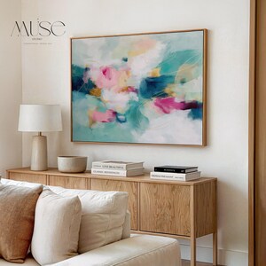 Horizontal floating framed canvas wall art in warm pink, teal, and golden hues. Styled in a neutral living room with soft textures and natural wood furniture. Ideal for dreamy bedrooms and warm minimalist interiors.