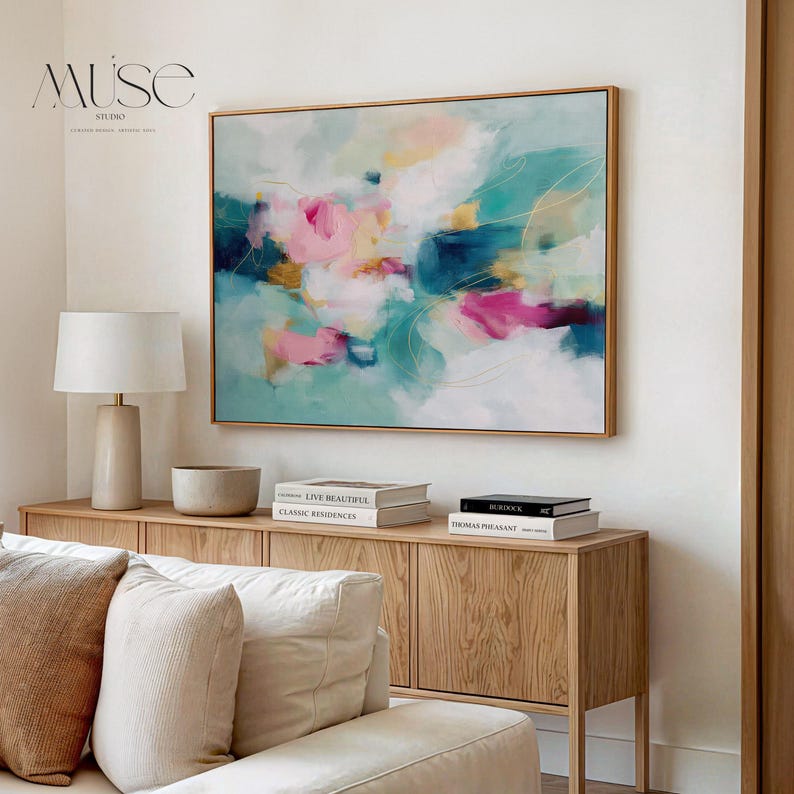 Horizontal floating framed canvas wall art in warm pink, teal, and golden hues. Styled in a neutral living room with soft textures and natural wood furniture. Ideal for dreamy bedrooms and warm minimalist interiors.