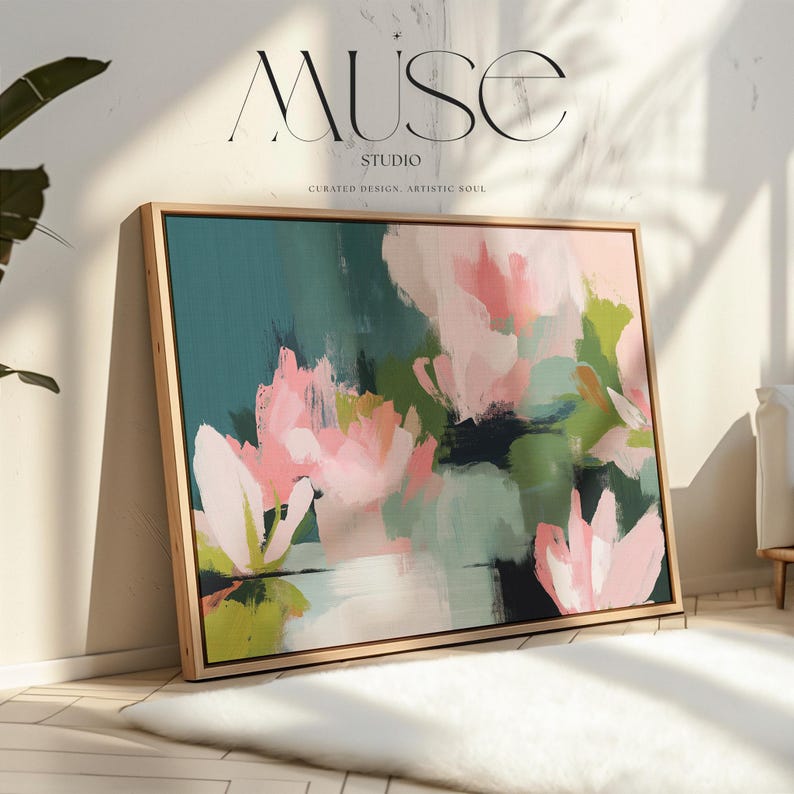 Magnolia Reverie No. 1037 by Muse Studio & Co. blush pink magnolia floral wall art with sage green and deep teal botanical brushwork printed with museum-grade giclée inks on premium gallery-wrapped cotton canvas and custom framed in natural wood with optional white, black, antique gold, or antique silver float frames to complement any decor style, styled in a coastal tropical beach home living room with airy interiors and light wood floors.