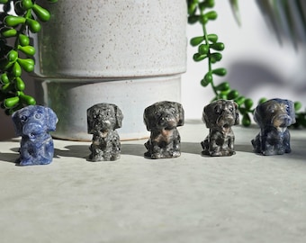 May include: Five small carved stone dog figurines. Four are grey and one is blue.