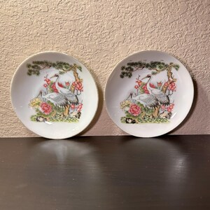 2 kleine, vintage Chinese borden met geschilderde vogels, rozen en bomen. Gemerkt.
