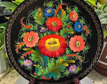 Plato decorativo de pared de estilo Petrykivka, pintado a mano con motivos florales, fondo negro y arte popular de Europa del Este.