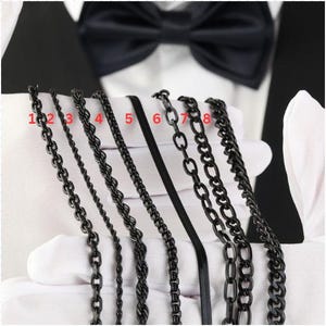 Op de afbeelding: Acht verschillende zwarte ketting stijlen genummerd van 1 tot 8. De kettingen worden weergegeven tegen een witte achtergrond.