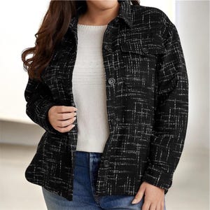 Puede incluir: Chaqueta a cuadros en blanco y negro con cierre de botones y dos bolsillos en el pecho. La chaqueta se lleva sobre un jersey blanco y unos vaqueros azules. La chaqueta tiene cuello clásico y mangas largas.