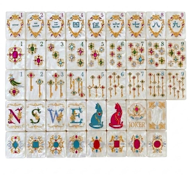 K&ouml;nnte beinhalten: Ein Set aus wei&szlig;en, perlmuttfarbenen Mahjong-Spielsteinen mit goldenen Filigranrahmen. Die Steine zeigen chinesische Ziffern von eins bis neun, bunte Edelsteincluster, goldene Schl&uuml;ssel, die Buchstaben N, S, W, E, Katzensilhouetten und einen Joker.