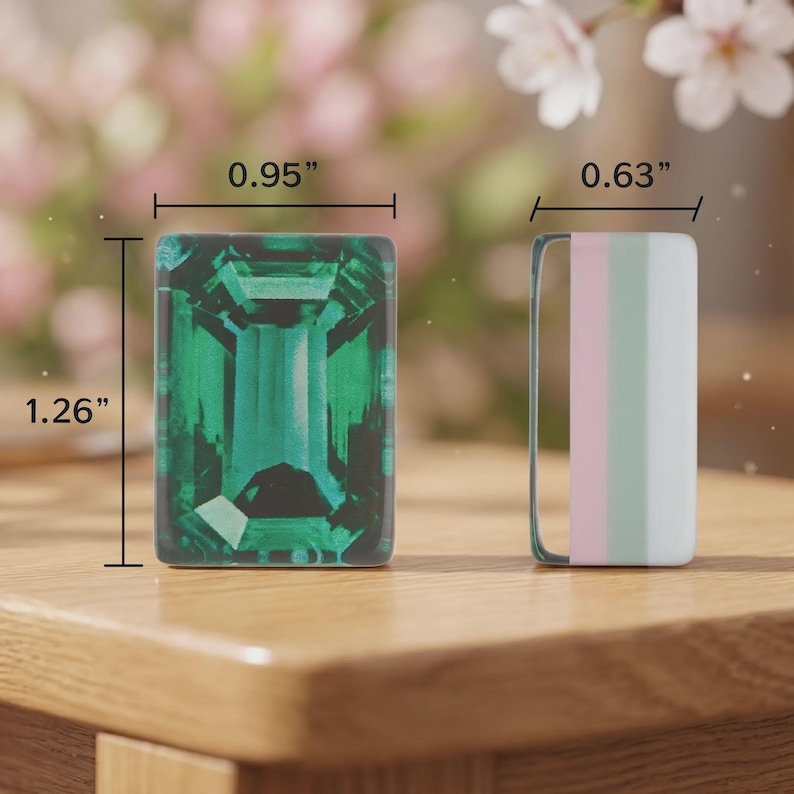 May include: A rectangular emerald green gemstone graphic measuring 0.95 inches by 1.26 inches next to a rectangular vertical striped charm in pink, light green, and white measuring 0.63 inches in width.