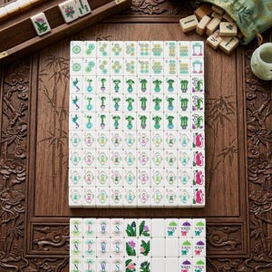 May include: A Mahjong set featuring white tiles with colorful engraved designs including numbers, bamboo stalks, flowers, tigers, and the letters N, E, W, S. The set includes a wooden tile rack, a green fabric drawstring bag, and a small cup.