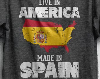 May include: Dark gray t-shirt with the text "LIVE IN AMERICA" above a map of the United States colored with the Spanish flag. Below the map, the text reads "MADE IN SPAIN WITH GENUINE PARTS."