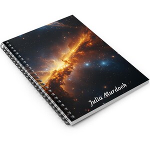 May include: A spiral bound notebook featuring a colourful nebula image on the cover. The name "Julia Murdoch" is printed on the bottom right corner of the cover.
