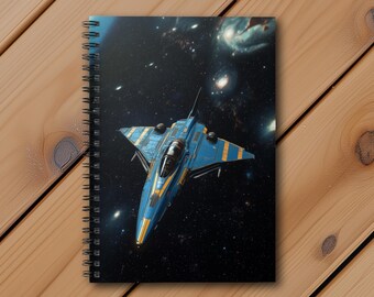 May include: A blue and yellow spaceship with a cockpit window flies through a dark space with stars and galaxies in the background. The spaceship is a notebook cover.