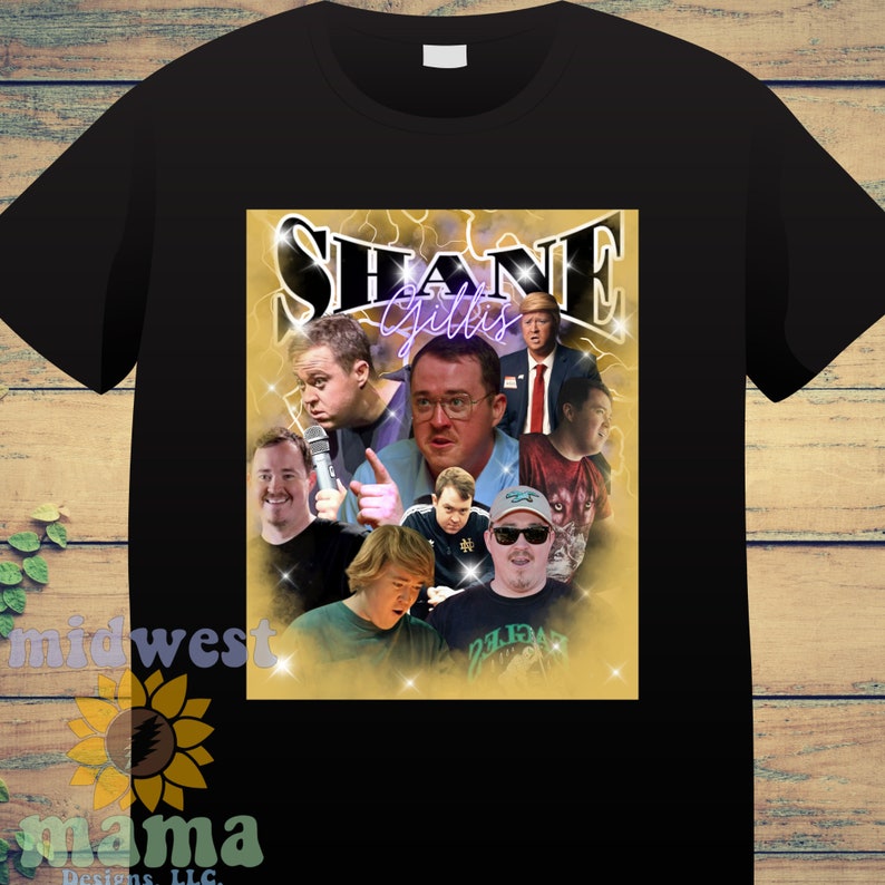 May include: A black t-shirt with a collage of images featuring Shane Gillis. The collage is set against a gold background with a purple neon outline of the text "SHANE GILLIS".