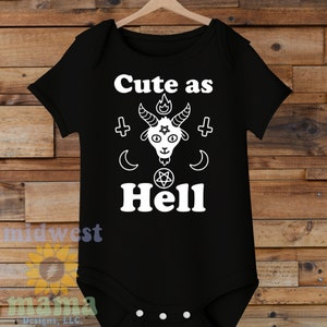 May include: Black baby onesie with white text that reads "Cute as Hell" and a white illustration of a goat with horns, a pentagram, and a flame above its head.