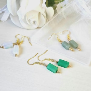May include: Two pairs of earrings with gold hooks and green and white rectangular gemstone beads.