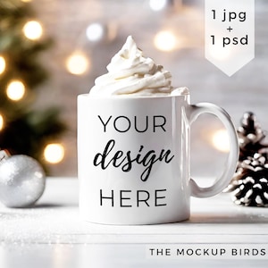 May include: White ceramic mug with a white whipped cream topping. The mug has the text "YOUR design HERE" printed on it. The mug is sitting on a white surface with a pine cone and a silver ornament in the background.