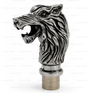 May include: A silver-toned metal cane handle shaped like a snarling wolf head with detailed fur texture and an open mouth. The handle features a cylindrical base with horizontal grooves, designed to attach to the top of a walking stick or cane.