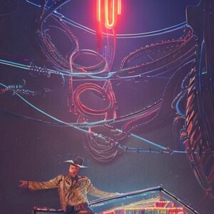 May include: A man wearing a cowboy hat and a patterned shirt stands on a stage with neon lights in the background. The stage is decorated with a neon sign that says "101".