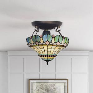 May include: A Tiffany-style ceiling light fixture with a bronze-colored base and a stained glass shade. The shade features a pattern of blue, green, and pink accents, with a cream-colored background. The light hangs from the ceiling.
