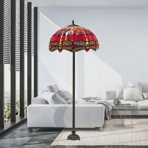 Può includere: Una lampada da terra in stile Tiffany con paralume in vetro colorato. Il paralume presenta un motivo a libellula rosso e giallo, con base e palo color bronzo. È un apparecchio di illuminazione decorativo.