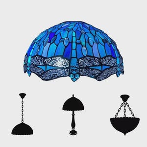 May include: A blue stained glass lampshade with a dragonfly design. The lampshade is dome-shaped and features various shades of blue glass. Silhouettes of different lamp styles are below the lampshade.