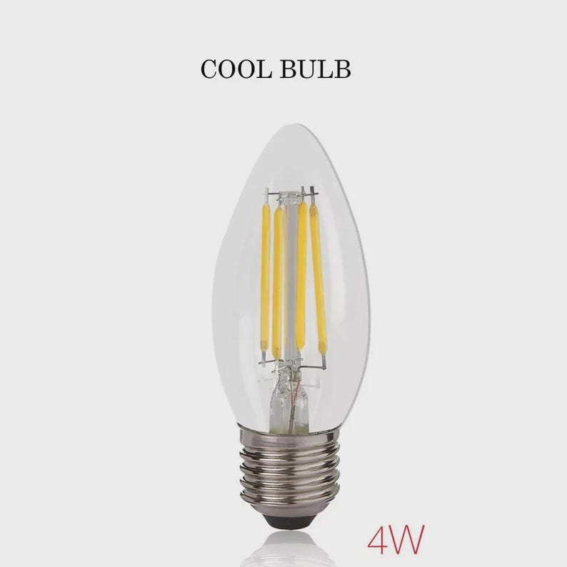May include: Clear glass LED light bulb with a candelabra base. The bulb has four vertical yellow filaments and the text "COOL BULB" above it. The base is silver and the wattage is 4W.