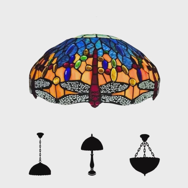 May include: A stained glass lampshade with a dragonfly design. The lampshade features a mosaic of blue, orange, red, green, and yellow glass pieces. The dragonfly's wings are white with black detailing. Silhouettes of three lamp styles are below.