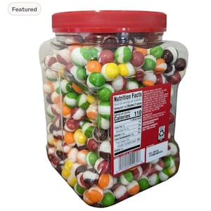 Peut inclure: Un grand bocal carré en plastique transparent rempli de bonbons ronds multicolores aux fruits. Le bocal est doté d'un couvercle rouge à visser et d'une étiquette nutritionnelle bien visible sur la face avant, détaillant les ingrédients.