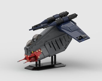 May include: A gray and blue spaceship model constructed from interlocking toy bricks. The model features a red and white front section, two clear cockpit domes, and two dark blue missile launchers on top. It is displayed on a black stand.