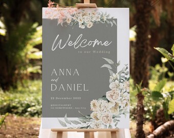 May include: A welcome sign for a wedding with a gray background and white floral design. The sign reads "Welcome to our Wedding Anna and Daniel 22 December 2022 @DIGITALBYBT 115 SOMEWHERE.. Any City".