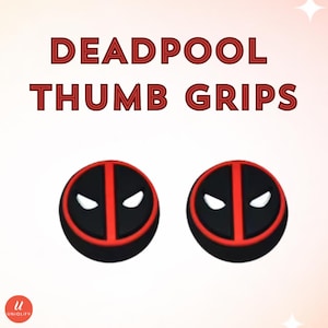 Puede incluir: Dos agarres de pulgar circulares con un diseño negro y rojo y aberturas blancas en forma de ojos, que se asemejan a una máscara. El texto DEADPOOL THUMB GRIPS aparece en letras rojas sobre los agarres. Se ve un pequeño círculo rojo con una u blanca.