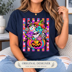 May include: A navy blue t-shirt featuring a vibrant graphic of a large, colorful jack-o'-lantern filled with various cartoon ghosts, candy, and stars. The design is set against a background of vertical pink stripes with colorful polka dots.
