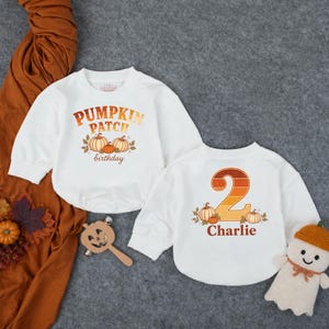 May include: Two white long-sleeve sweatshirts. One features the text PUMPKIN PATCH birthday with orange pumpkin illustrations. The other features a large orange gradient number 2, the name Charlie, and pumpkin illustrations with autumn leaves.