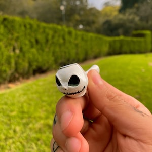 May include: White ceramic pipe with a black and white Jack Skellington design.