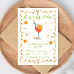 An invitation over a brown envelope that reads “a spritz older. celebrate Olivia’s 25th birthday”. orange scribble style border. small orange slices and hearts throughout design. an image of an aperol spritz