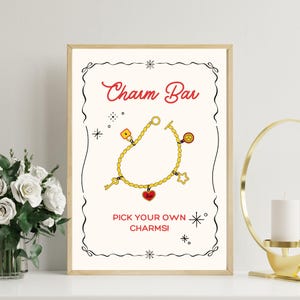 Peut inclure: Une affiche encadrée avec les mots "Charm Bar" en script rouge. L'image présente un bracelet de charme doré avec divers breloques, dont une clé, un cadenas, un cœur et une étoile. Le texte "Pick Your Own Charms!" est en dessous.