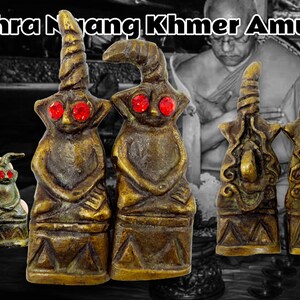 Può includere: Cinque amuleti khmer antichi in bronzo con occhi di vetro rosso. Gli amuleti sono di varie forme e dimensioni, e alcuni hanno intagli intricati. Gli amuleti sono disposti su una superficie scura.
