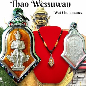 May include: Two silver and gold Thai amulets, one with a depiction of a deity, the other with a symbol. The amulets are on a red velvet background with a necklace with brown beads.