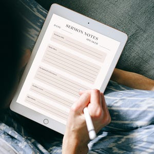 Può includere: Un tablet digitale che mostra un modello per appunti di sermoni con campi per data, titolo del sermone, oratore, idea principale, riferimenti scritturali, versetto d'oro e domande, con riquadri di testo rosa chiaro.