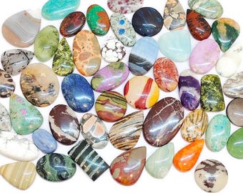May include: A collection of polished gemstones in various shapes and colors, including oval, teardrop, and round. The gemstones feature a range of patterns and hues, such as blue, green, brown, and purple. The stones are displayed on a white background.