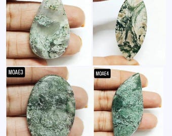 May include: Four moss agate cabochons in various shapes and sizes. The stones are a mix of green and white with a swirling pattern.