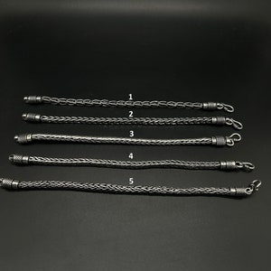 Könnte beinhalten: Fünf silberne Armbänder mit verschiedenen Kettenstilen. Die Armbänder sind in einer Reihe angeordnet und von 1 bis 5 nummeriert.