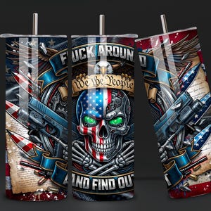 May include: A set of three stainless steel tumblers with a patriotic design. Each tumbler features a skull with an American flag design, guns, and the text "F*ck Around and Find Out" and "We the People". The design incorporates red, white, and blue colors.